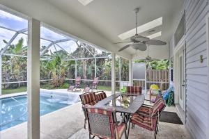 un patio con mesa, sillas y piscina en Cocoa Beach Paradise with Indoor and Outdoor Fun! en Merritt Island