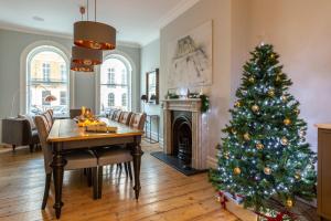 un árbol de Navidad en una sala de estar con mesa en Luxury Mansion Townhouse with Private Cinema, en Brighton & Hove