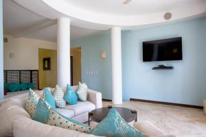 a living room with couches and a flat screen tv at Villa Turquesa in Playa del Carmen
