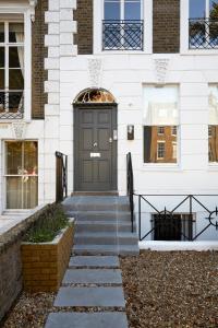 een voordeur van een wit gebouw met een trap bij Cosy Loft Apartment - minutes from Angel Tube St. in Londen