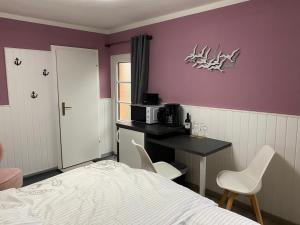 1 dormitorio con 1 cama y escritorio con microondas en Ferienzimmer Am Strom 34, en Rostock 6 fotos más