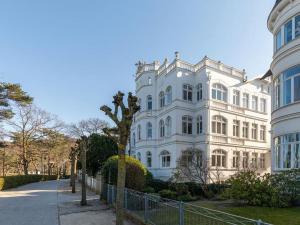 ein großes weißes Gebäude mit einem Baum davor in der Unterkunft Villa Vogue Wohnung Nr. 11 in Binz