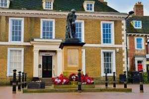 uma estátua de um homem em frente a um edifício em Black Bull Godmanchester em Huntingdon