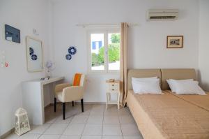 a bedroom with a bed and a desk and a window at Marias Rooms in Ios Chora