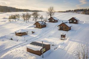 an aerial view of a snow covered field with cabanas at Domki Pod Roztóczką in Hoczew