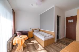 Kleines Zimmer mit einem Bett und einem Tisch in der Unterkunft Hotel Joh in Bad Salzuflen