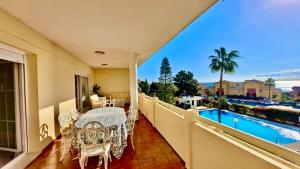 uma varanda com uma mesa e cadeiras e uma piscina em CABOPINO, Las Mimosas em Marbella