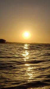 una puesta de sol sobre el agua con el sol en el cielo en Hotel BAHÍA, en Tela