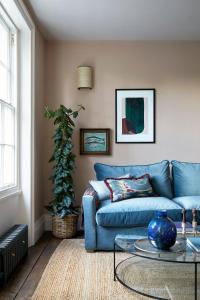 倫敦的住宿－Luxurious 1 Bedroom Apartment - minutes from Angel Tube St.，客厅配有蓝色的沙发和桌子