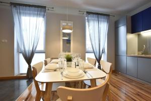 a dining room with a white table and chairs at Apartament Flauta Pogorzelica in Pogorzelica