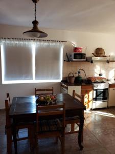 a kitchen with a table with a bowl of fruit on it at Casita de las Sierras in Río Ceballos