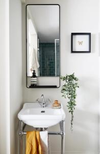 een badkamer met een wastafel en een spiegel bij Modern 1 Bedroom Apartment - minutes from Angel Tube St. in Londen