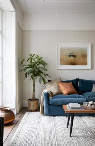 a living room with a blue couch and a plant at Modern 1 Bedroom Apartment - minutes from Angel Tube St. in London
