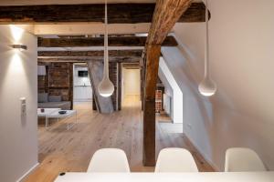 a living room with white chairs and wooden beams at Johannis Suite - Schrangen-Suites-1389 in Lüneburg