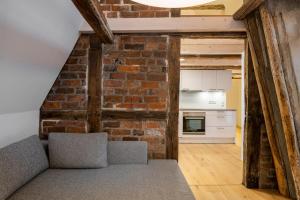 a kitchen and living room with a brick wall at Johannis Suite - Schrangen-Suites-1389 in Lüneburg