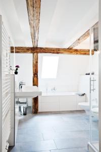 ein Badezimmer mit einem Waschbecken und einer Badewanne in der Unterkunft Johannis Suite - Schrangen-Suites-1389 in Lüneburg
