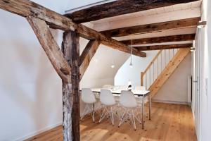 a dining room with wooden beams and a table and chairs at Johannis Suite - Schrangen-Suites-1389 in Lüneburg