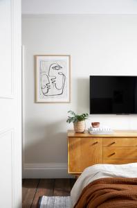 sypialnia z łóżkiem i telewizorem na komodzie w obiekcie Modern 1 Bedroom Apartment - minutes from Angel Tube St. w Londynie