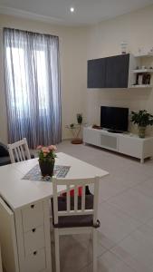 een woonkamer met een witte tafel en een tv bij Casetta Delia in Palermo