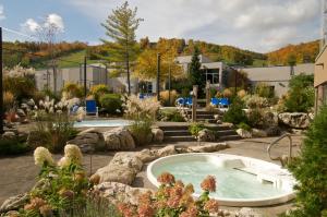 un bain à remous dans un jardin avec des rochers dans l'établissement Blue Mountain Resort Inn, à Blue Mountains