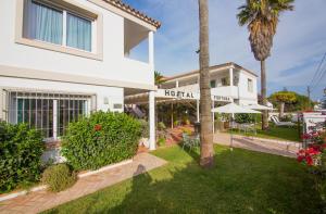 una casa blanca con un patio con un hotel en Fortuna en Los Caños de Meca