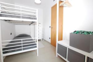 a room with a white bunk bed and a plant at Petit niu · Petit niu · Apartamento AC - 3 min de la playa in Vilassar de Mar