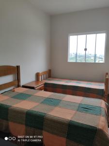 a bedroom with two beds and a window at Casa aconchegante perto da Uel in Londrina