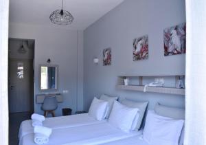 a bedroom with a white bed and white pillows at Liprando in Naousa