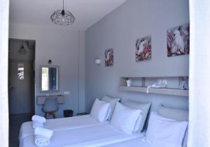 
a bedroom with a white bed and white walls at Liprando in Naousa
