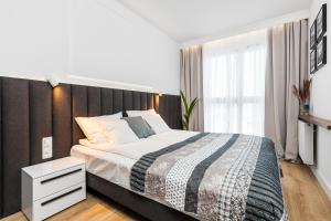 a bedroom with a large bed with a black headboard at "NOWY APARTAMENT" sypialnia , garaż, 1500 m od morza, Netflix in Gdańsk