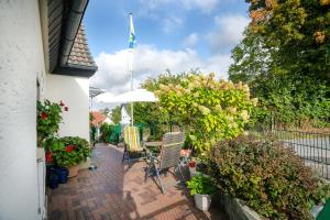 eine Terrasse mit einem Tisch, Stühlen und Pflanzen in der Unterkunft Casa Felicitas - Ferienwohnung & Studio in Möhnesee