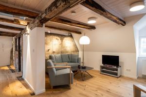 Michaelis Suite - Schrangen-Suites-1389 في لونبورغ: غرفة معيشة مع أريكة وتلفزيون