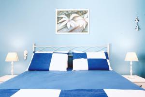1 dormitorio azul con 1 cama azul y 2 lámparas en Casa Boarni Leuca, en Leuca