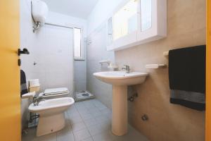 bagno bianco con lavandino e servizi igienici di Casa Boarni Leuca a Leuca