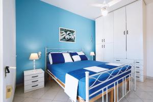 Dormitorio azul con cama y pared azul en Casa Boarni Leuca, en Leuca