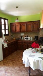 a kitchen with a table with flowers on it at Location de vacance au coeur du Périgord Noir in Le Bugue