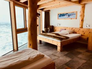 1 Schlafzimmer mit 2 Betten in einem Zimmer mit Fenstern in der Unterkunft Lodge am Krippenstein in Obertraun