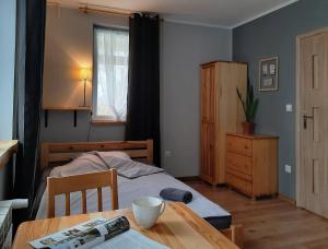 a small bedroom with a bed and a table with a bowl on it at Gospodarstwo Gościnne Księżycówka in Rajbrot