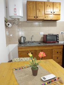 a kitchen with a table with a flower on it at Departamentos Pachamama in Tunuyán