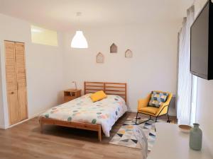 a bedroom with a bed and a chair at Studio hyper centre avec balcon in Châteauroux