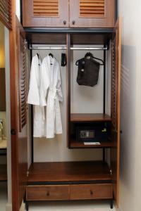 a wardrobe with white clothes and a purse at TreeHouse Boutique Hotel, an adults only boutique hotel in Mérida