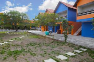 Pousada Agreste Water Park في كاروارو: مبنى باللون الأزرق والبرتقالي بجوار ساحة الفناء