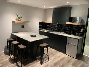 a kitchen with a island with stools and a counter top at Coral Wood Self Catering Suites and B&B in East London
