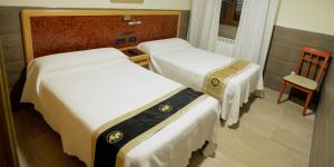 a hotel room with two beds and a chair at Domus Viatoris in Sahagún