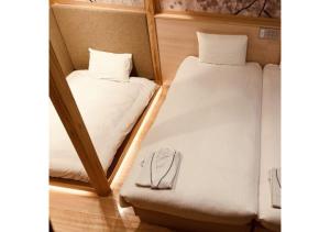 two beds in a small room with a mirror at Sakura Sky Hotel - Vacation STAY 18432v in Tokyo