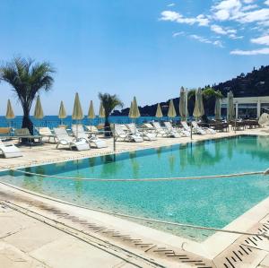 una gran piscina con tumbonas y sombrillas en Villa Eva Beach, en Ventimiglia