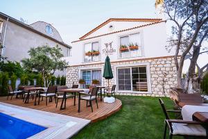 a patio with tables and chairs and a swimming pool at Rebetiko Hotel in Alaçatı