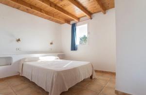 a white room with a bed with a window at CASA LAIA Cala Saona in Cala Saona