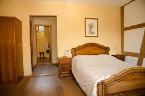 a bedroom with a bed with a wooden bed frame at Ferme Auberge du Moulin des Sept Fontaines in Drachenbronn