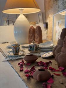 - une table avec des biscuits, des assiettes et une lampe dans l'établissement Locanda Tipica Sa Corte, à Oliena